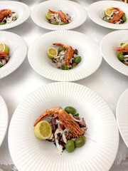 dish ready to be served with seafood salad and a red prawn as decoration