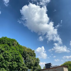 Obraz premium clouds over the old town. the sky is clear and bright and the clouds are scattered throughout the sky. blue sky with white clouds.