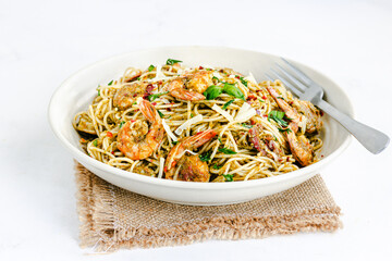 Shrimp Pesto Pasta Garnished with Fresh Basil Leaves and Cheese Low Angle Close Up Photo