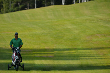 A golfer walks along a lush green fairway carrying a golf bag a sunny day at an outdoor course concept