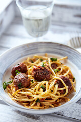 Spaghetti Pasta with Meatballs and fresh Basil o bright background. Close up.