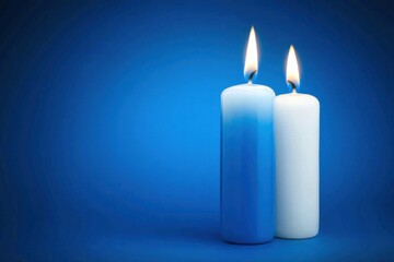 Two candles, one blue and one white, glow softly against a blue backdrop, creating a tranquil ambiance perfect for relaxation