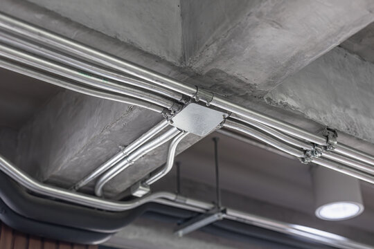 IMC Intermediate Metallic Conduit curving and angular bending, Electricity cable installation at ceiling for safety.