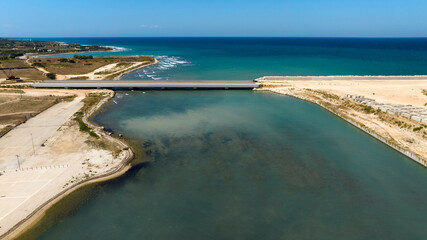 Aerial view of a bridge connecting two lands divided by the sea.