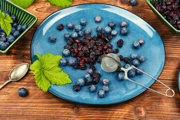Fresh and dried berries on wooden table.