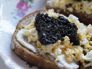 Gourmet Sandwich with Black Caviar, Egg, and Cheese for a Festive Breakfast