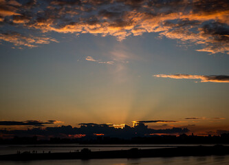 オレンジ色に光る夕焼け空と光芒が美しい景色