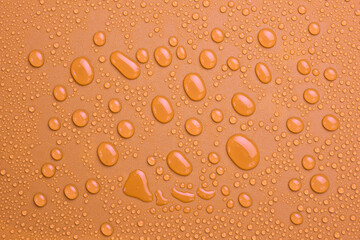 Close-up Drops of water on a yellow-gold background. Macro photo. Top view.
