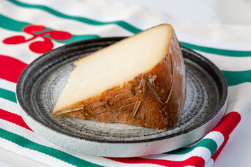Piece of tasty Basque Brebis Fume smoked sheep cheese produced in south-western France, Northern...