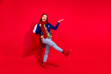 Full size photo of young girl hold empty space gift sack dance wear trendy blue christmas outfit masquerade theme party on red background