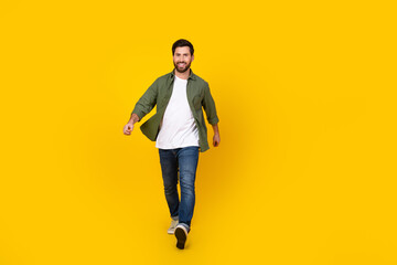 Full size photo of nice young man walk empty space ad wear shirt isolated on yellow color background