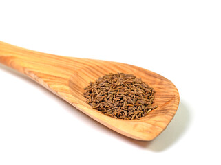 Kümmelsamen auf einem Kochlöffel vor weißem Hintergrund