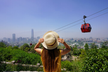 Holidays in Santiago de Chile. Rear view of beautiful fashion girl enjoying view of cable cars in...