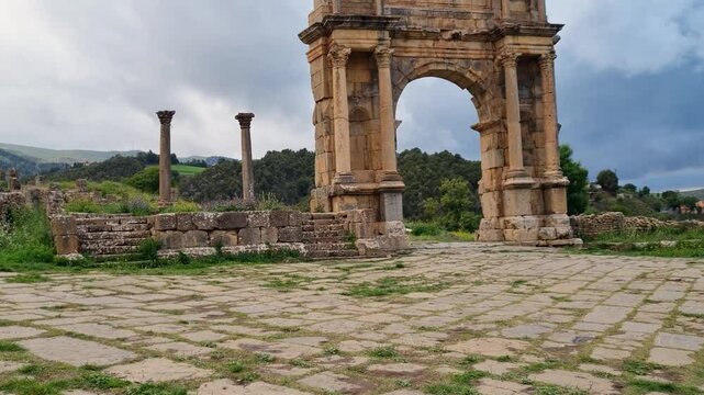 Revealing shot of Roman Caracalla gate in Djemila Algeria on a cloudy day