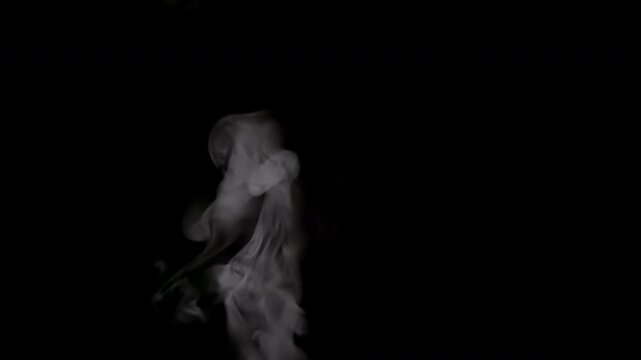 Steam from a Cup of Boiling Water. White smoke on black background