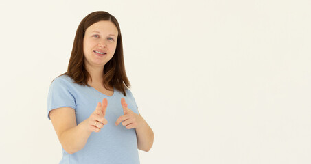 Young happy woman she wears blue t-shirt casual clothes point index finger camera on you motivating encourage isolated on white background studio. Lifestyle concept