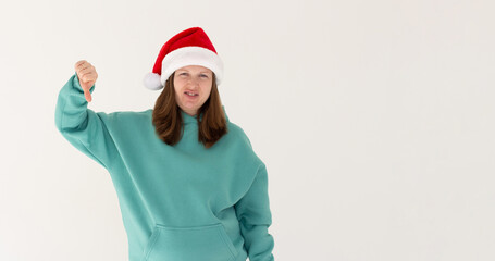 Beautiful european woman wearing christmas hat looking unhappy and angry showing rejection and negative with thumbs down gesture. Bad expression.