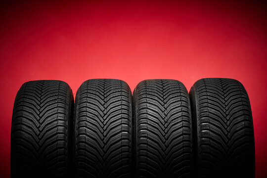 Fototapeta Car tires, winter wheels isolated on red background