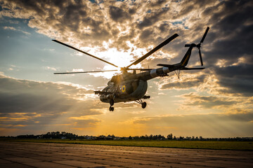 Military helicopter in the air at sunset