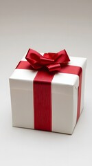 Obraz premium Elegant white gift box with a red ribbon and bow, perfect for celebrations.