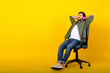 Full length portrait of nice young man sit chair sleep wear shirt isolated on yellow color...