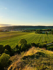 Scenic rural landscape with fields and village at sunset