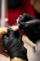 Men's manicure. Male hand undergoing a manicure procedure. The master does a man's manicure. A manicurist files a man's nails in a salon. Hygiene and hand care for men. Men's manicure design.