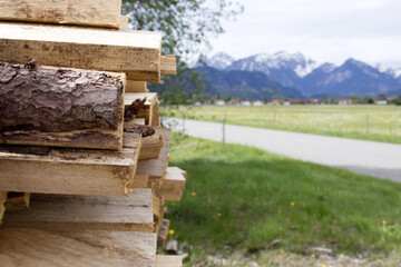 Naklejka premium Stacked firewood prepared for the season against the backdrop of mountainous terrain