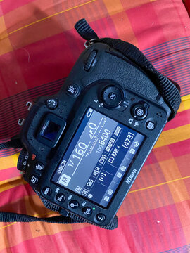 Nikon dslr camera displaying settings on red plaid background
