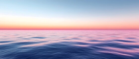 Obraz premium A serene seascape at sunset, showcasing a calm ocean surface reflecting soft pink and blue hues across the horizon, creating a tranquil and peaceful atmosphere.