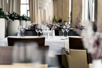 The restaurant features a stylish and contemporary interior complete with elegant table settings and vibrant plants.