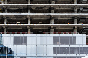 A large concrete building is under construction, featuring visible scaffolding and various structural elements