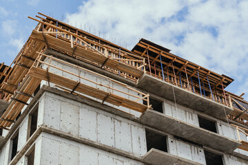 Obraz premium The ongoing construction of a multistory building features cranes and scaffolding raised overhead