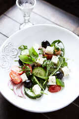 Healthy Salad with Feta Cheese, Black Olives, Cucumber and Cherry Tomatoes. Bright background. Close up.