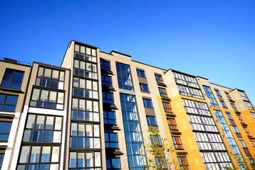 Modern facade building. Facade of high rise urban Modern house. balcony and Windows. Architecture building exterior, house block. High Rise house. Residential development in UK. City built. Blue sky.