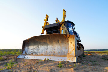 Dozer at construction site, utility trenching. Earth-moving machinery. Bulldozer at road construction. Earth-moving equipment at road work, land clearing, grading, pool excavation, utility trenching.