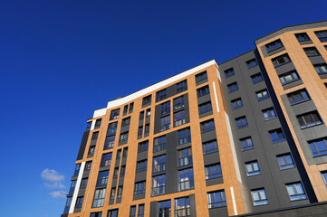 Modern facade building. Facade of high rise urban Modern house. balcony and Windows . Architecture building exterior, house block. High Rise house. Residential development in UK. City built. Blue sky.