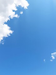 Vibrant clear blue sky background with fluffy white clouds, copy space, atmosphere