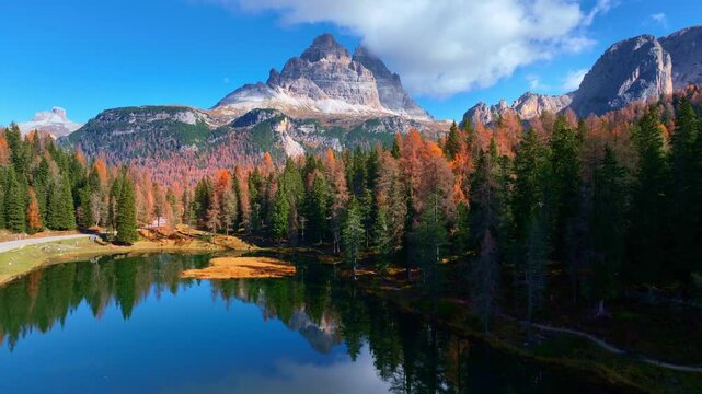 Establishing drone view of autumn in the Dolomites in Italy, beautiful lake Antorno in the Dolomite mountains, Tre Cime di Lavaredo national park in Italy in autumn. 