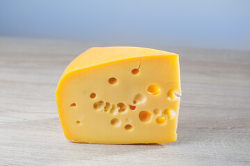 maasdam cheese on wooden background, close-up view