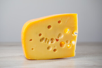 maasdam cheese on wooden background, close-up view