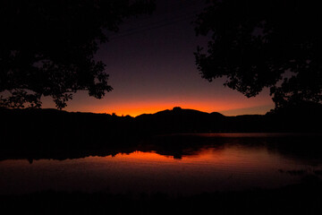 Obraz premium Sunset reflecting with red/orange hue in Sete Cidades volcanic lake in San Miguel island in Azores