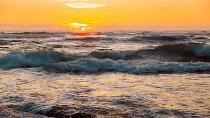 Obraz premium Tranquil Ocean Waves At Sunset With Golden Sky