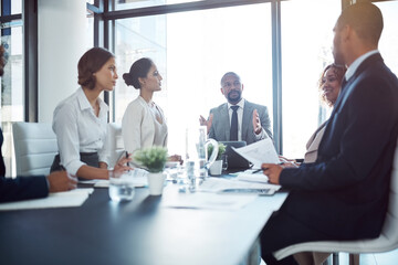 Business people, documents and meeting in boardroom of office for conversation or planning. Corporate, paperwork and teamwork with employee group in workplace for collaboration or development