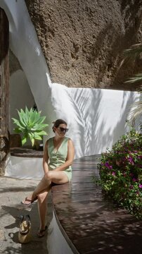 Woman relaxing in lagomar lanzarote canary island surrounded by beautiful greenery rock formations and white architecture