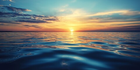 Fototapeta premium A peaceful ocean stretches to the horizon under a colorful sunset sky filled with hues of orange and blue.