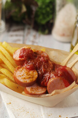Currywurst lightly topped with curry and served with chips
