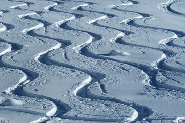Almost symmetrical traces of skiing in powder off-piste snow