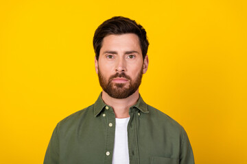 Photo of nice young man calm serious face wear khaki shirt isolated on yellow color background