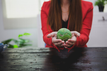 An Asian woman in a bright red shirt passionately advocates for the environment. Her commitment to...